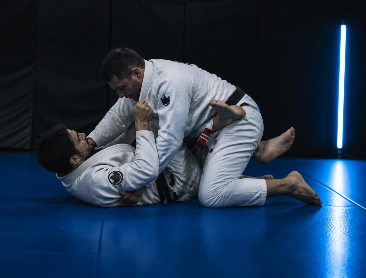 Two adults drilling grappling control positions on the mats at TD Athletics Brooklyn